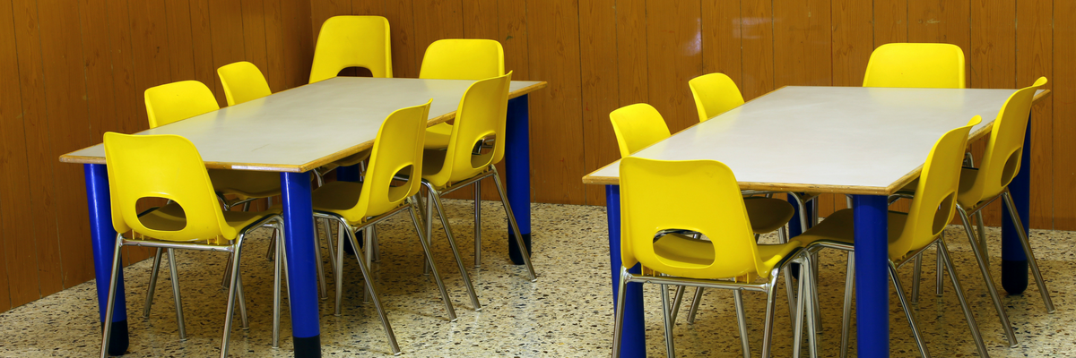 Empty tables and chairs in a children's classroom | Sparkhouse Blog