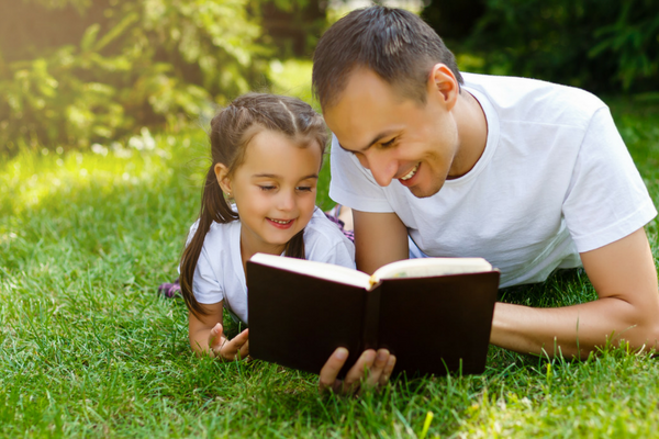 A young girl and man read the Bible together | Sparkhouse Blog