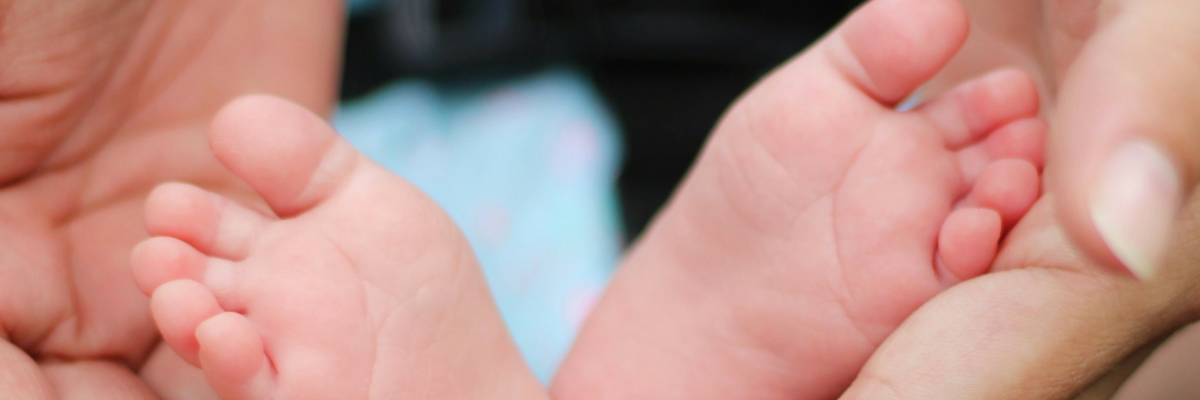 Parent cradles baby's feet | Sparkhouse Blog