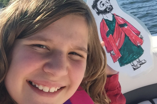 Girl smiles with Flat Jesus on a lake | Sparkhouse Blog
