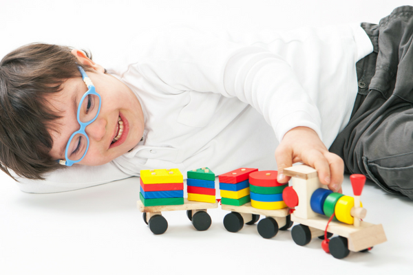 Boy with special needs plays with a train | Sparkhouse Blog