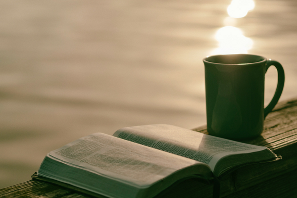 Photo of a Bible, coffee, and the sun shining—perfect for quiet Holy Week reflection | Sparkhouse Blog