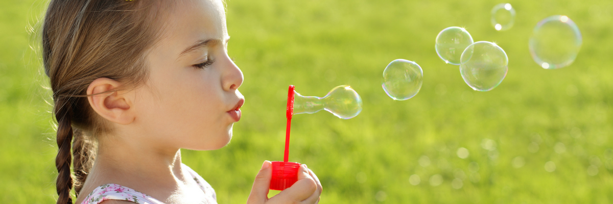 Young girl blows bubbles | Sparkhouse Blog