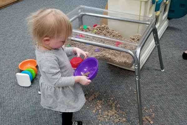 Little girl plays with sand in her church preschool | Sparkhouse Blog