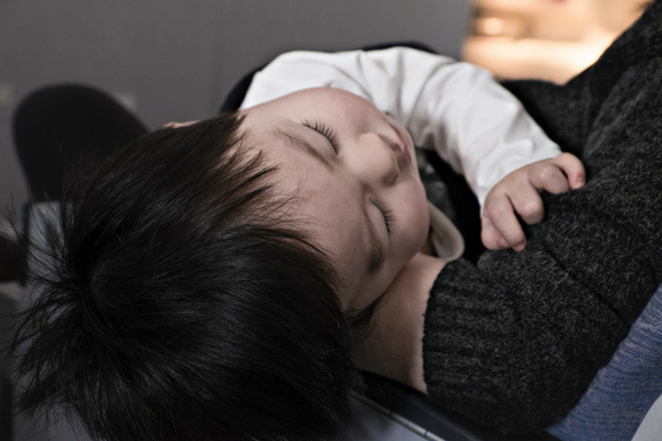 Baby sleeps in caregiver's arms | Sparkhouse Blog