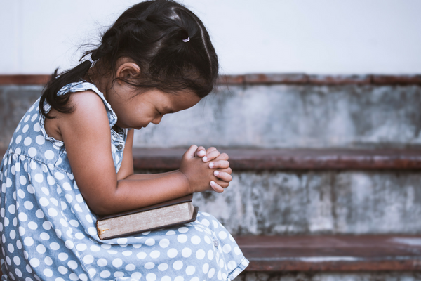 A little girl prays in her Sunday dress | Sparkhouse Blog