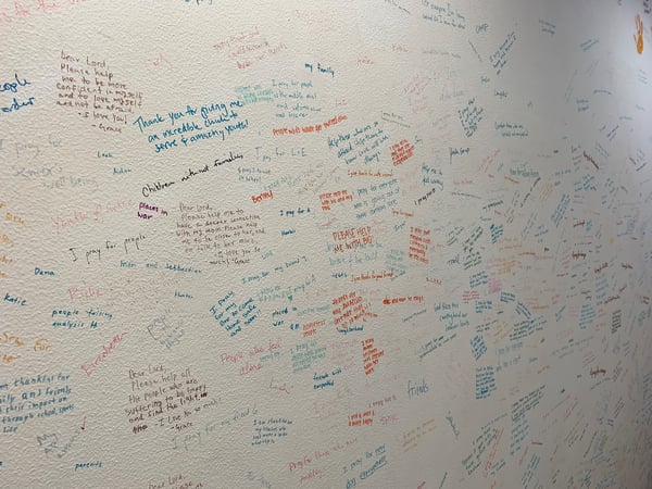 A wall with prayers written on it in sharpie