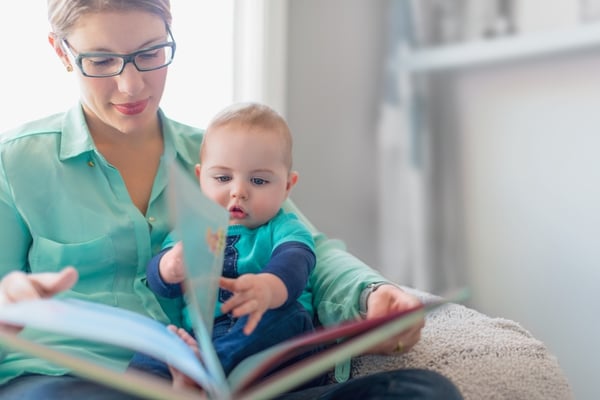 Cute baby reading with his mother